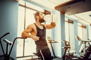 adam büyük şişe spor salonunda egzersiz basılı tutma veya içecek sudan sonra rahatlatıcı