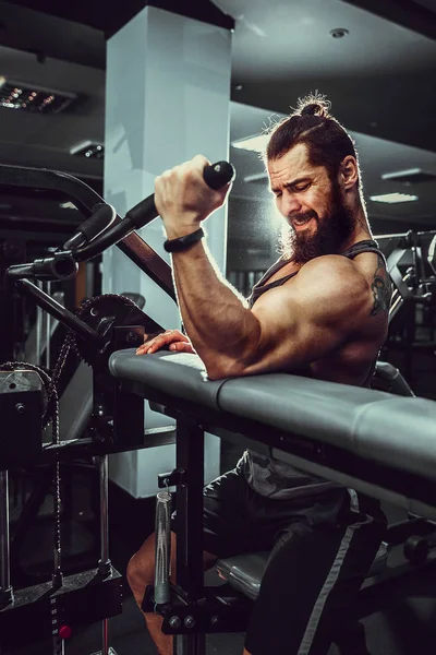 Homme faisant un exercice de poids lourd pour les biceps sur la machine Dans une salle de gym — Photo