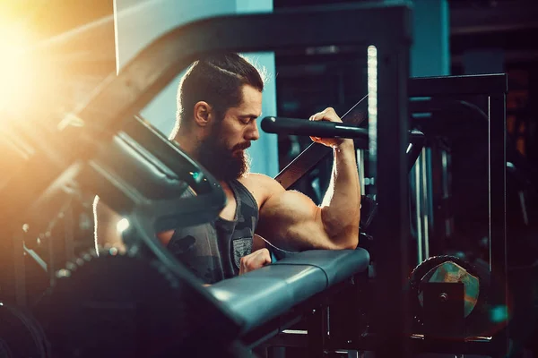 Homem fazendo exercício de peso pesado para bíceps na máquina Em um ginásio — Fotografia de Stock
