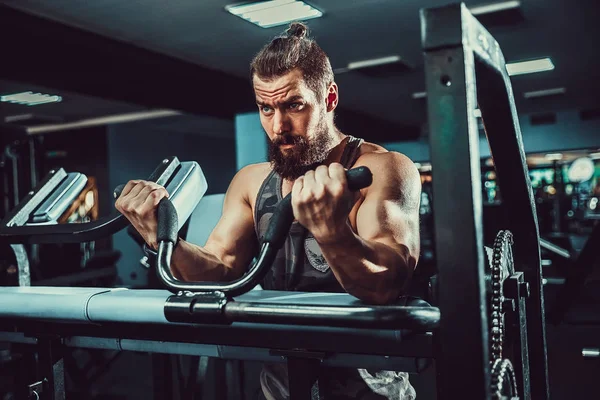 Ο άνθρωπος που κάνει την άσκηση βαρέων βαρών για δικέφαλους μυς σε μηχανή σε ένα γυμναστήριο — Φωτογραφία Αρχείου