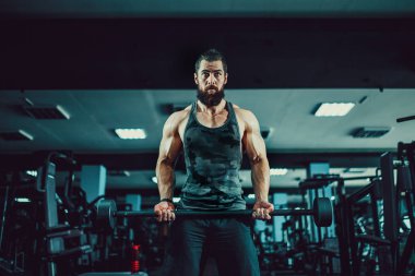 Halter salonunda ile çalışmaları yapan kaslı vücut geliştirmeci adam