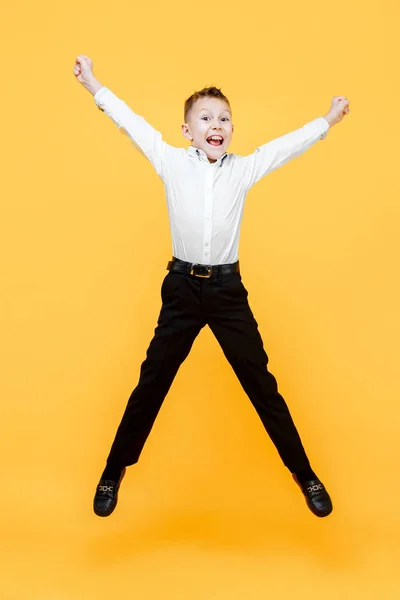 Boldog iskolás ugráló örömében. Boldogság, a tevékenység és a gyermek koncepció. — Stock Fotó