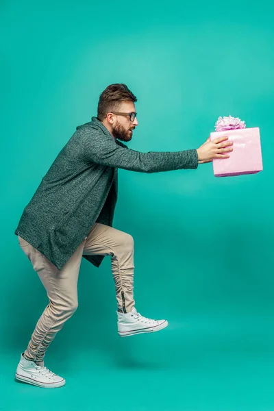 Чоловік позує комічно з подарунковою коробкою — стокове фото
