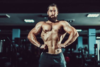 Spor salonunda poz atlet kaslı vücut geliştirmeci adam.