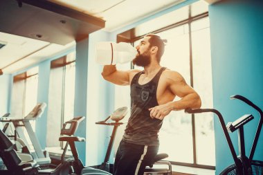 adam büyük şişe spor salonunda egzersiz basılı tutma veya içecek sudan sonra rahatlatıcı