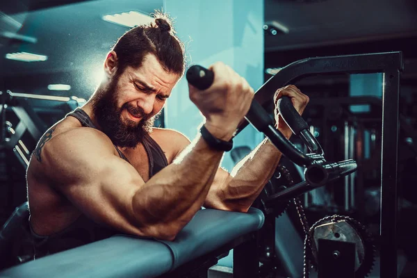 Homme faisant un exercice de poids lourd pour les biceps sur la machine Dans une salle de gym — Photo