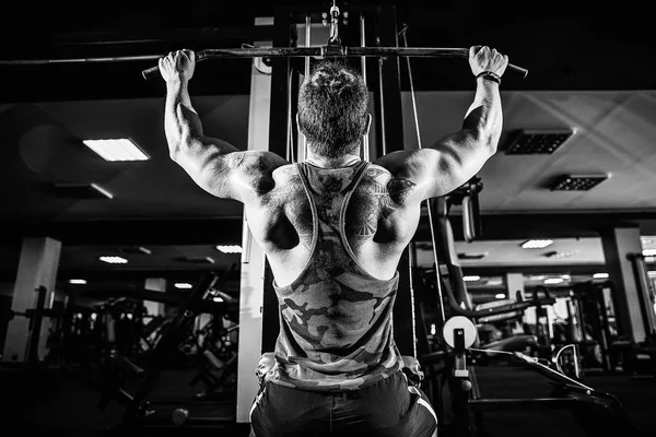 Ισχυρή Bodybuilder κάνει βαρύ βάρος άσκηση για πίσω στη μηχανή — Φωτογραφία Αρχείου