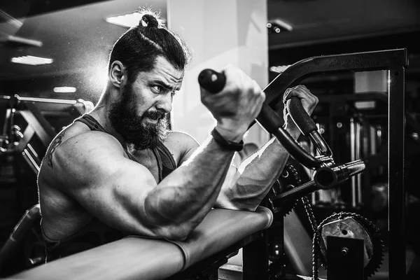 Hombre haciendo ejercicio pesado para bíceps en la máquina en un gimnasio —  Fotos de Stock