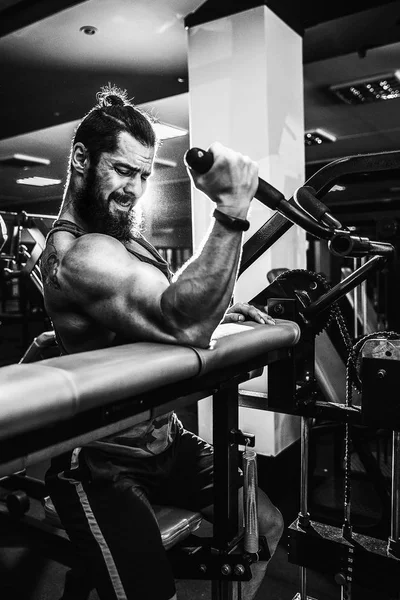 Hombre haciendo ejercicio pesado para bíceps en la máquina en un gimnasio — Foto de Stock