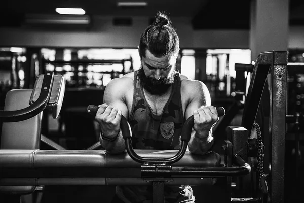 Pazı bir spor salonunda makinede için ağır egzersiz yapan erkek