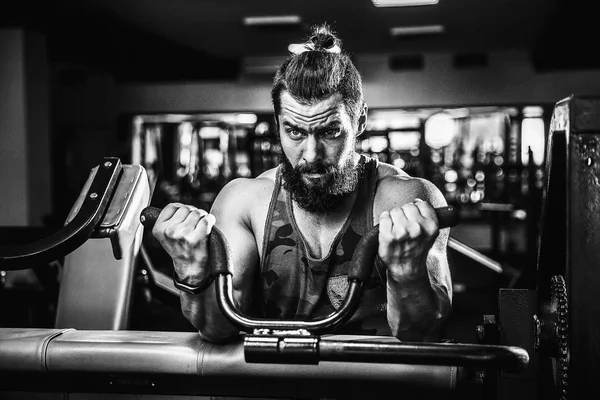 Pazı bir spor salonunda makinede için ağır egzersiz yapan erkek — Stok fotoğraf