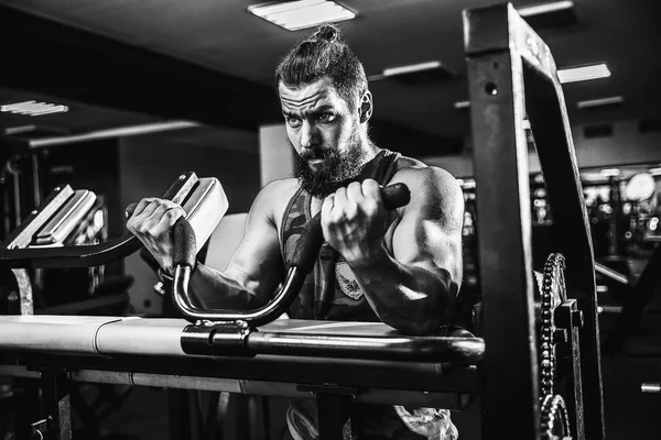 Hombre haciendo ejercicio pesado para bíceps en la máquina en un gimnasio — Foto de Stock