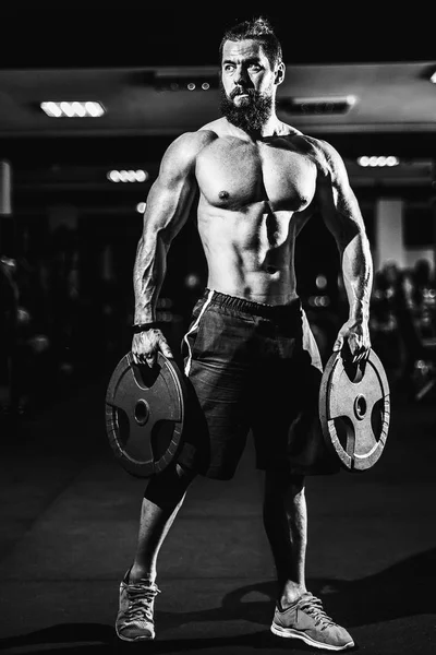 Atleta musculoso culturista hombre posando con pesas en el gimnasio . —  Fotos de Stock