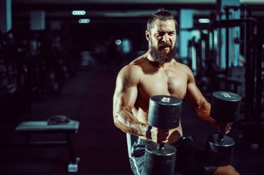 Spor salonunda kameraya poz güçlü adam büyük kaslı