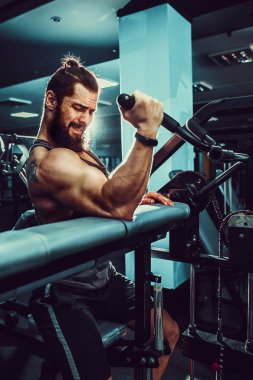 Pazı bir spor salonunda makinede için ağır egzersiz yapan erkek