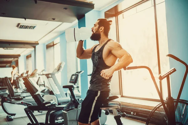 Adam büyük şişe spor salonunda egzersiz basılı tutma veya içecek sudan sonra rahatlatıcı — Stok fotoğraf