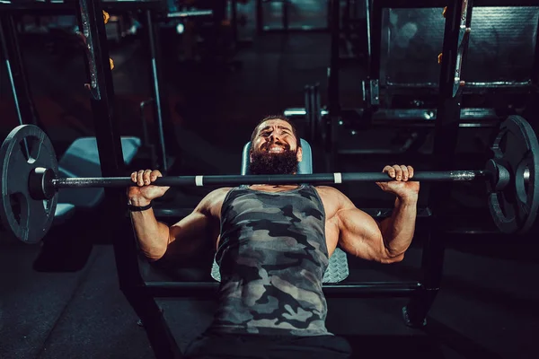 Jovem bonito fazendo exercício supino no ginásio — Fotografia de Stock