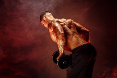 Kaslı adam egzersizleri yapıyor dumbbells ile. Beyaz arka plan üzerinde izole çıplak gövde ile güçlü erkek fotoğrafı. Güç ve motivasyon. Arkadan Görünüm.