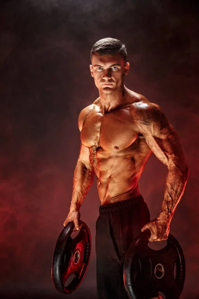 Bodybuilder met halters in zijn armen — Stockfoto