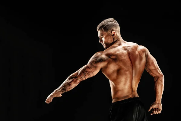 Culturista posando. Fitness hombre musculoso sobre fondo oscuro. —  Fotos de Stock