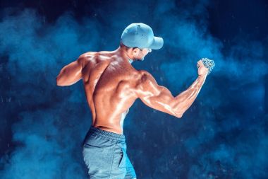 Yumruğunu duman üzerine örgülü zincirlerle yumruk yaparken ciddi kas avcı