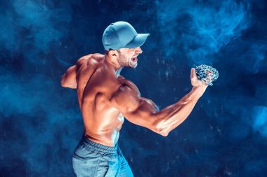 Yumruğunu duman üzerine örgülü zincirlerle yumruk yaparken ciddi kas avcı