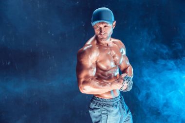 Yumruğunu duman üzerine örgülü zincirlerle yumruk yaparken ciddi kas avcı