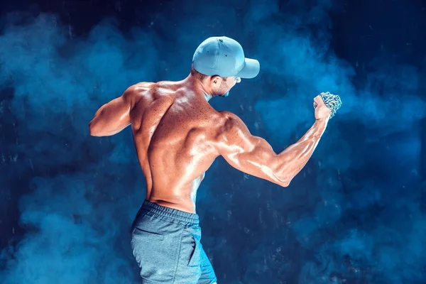 Serious muscular fighter doing the punch with the chains braided over his fist in smoke — Stock Photo, Image