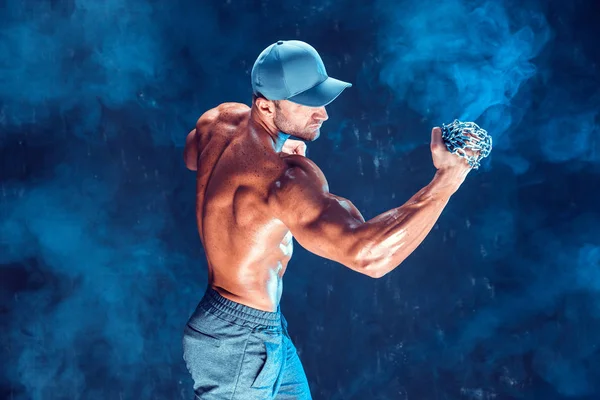 Yumruğunu duman üzerine örgülü zincirlerle yumruk yaparken ciddi kas avcı