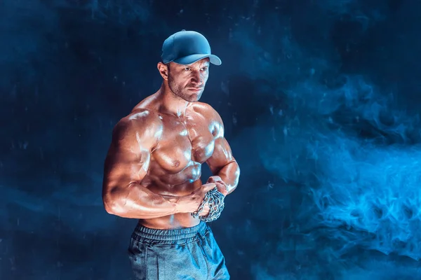 Yumruğunu duman üzerine örgülü zincirlerle yumruk yaparken ciddi kas avcı