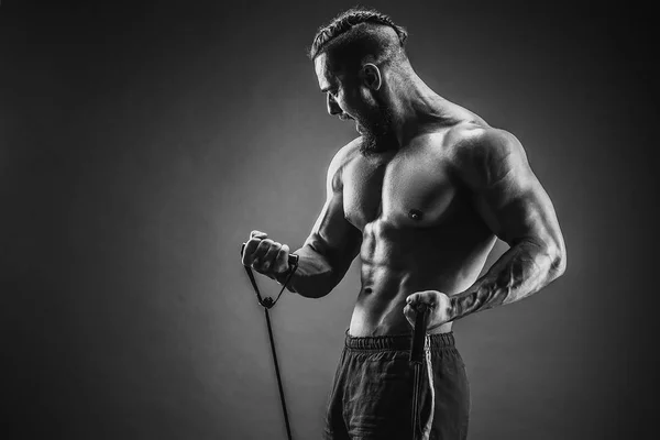 Hombre de fitness haciendo ejercicio con banda elástica. Hombre de deportes musculares —  Fotos de Stock