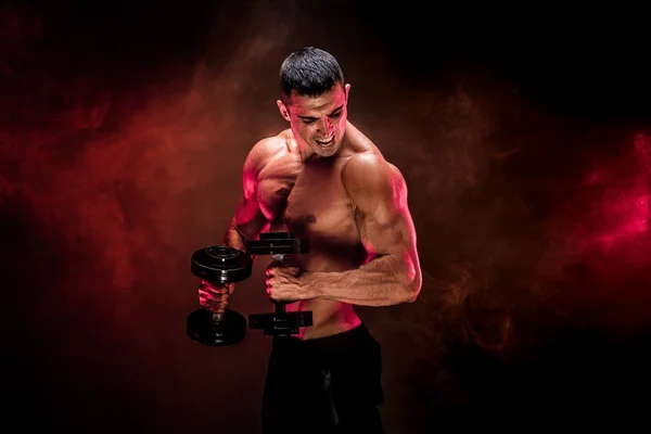 Homme musclé concentré faisant de l'exercice avec haltère — Photo