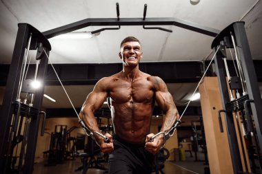 vücut geliştirmeci spor salonunda crossover kablo ile göğsüne üzerinde çalışıyor.