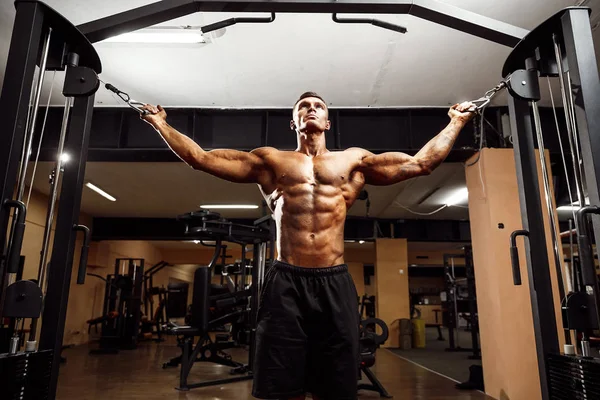 Culturista está trabajando en su pecho con cable cruzado en el gimnasio . — Foto de Stock