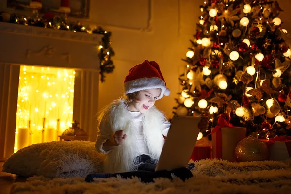 Flicka med tablett nära julgran — Stockfoto