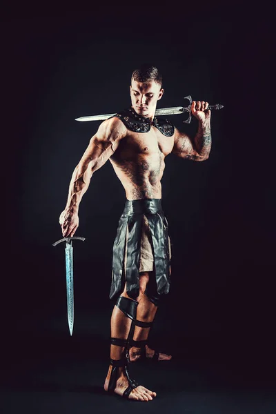 Severe barbarian in leather costume with sword — Stock Photo, Image