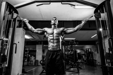 vücut geliştirmeci spor salonunda crossover kablo ile göğsüne üzerinde çalışıyor.