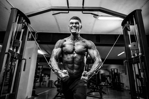 Culturista está trabajando en su pecho con cable cruzado en el gimnasio . — Foto de Stock