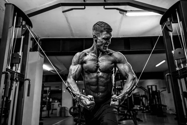 Culturista está trabajando en su pecho con cable cruzado en el gimnasio . — Foto de Stock