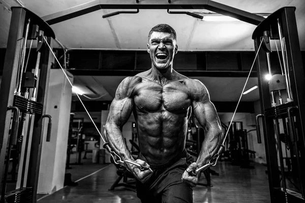 Culturista está trabajando en su pecho con cable cruzado en el gimnasio . — Foto de Stock