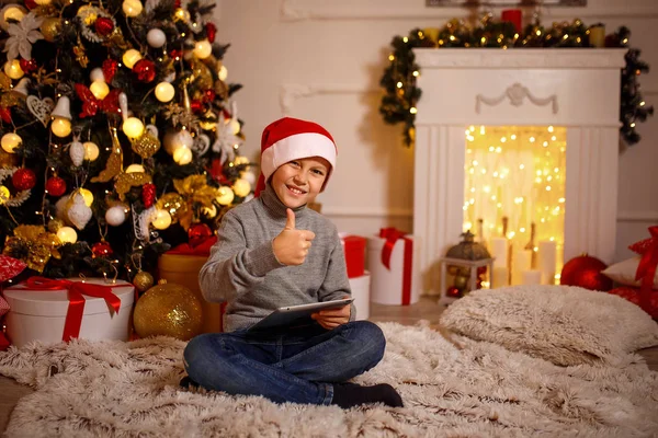 Niño en sombrero de Navidad gesto pulgar hacia arriba —  Fotos de Stock