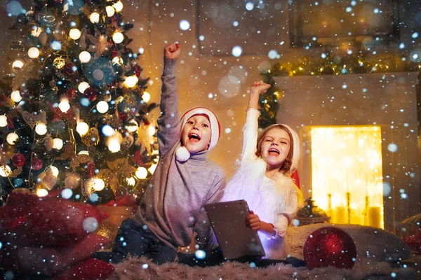 クリスマス ツリーの近くにタブレットを使用して驚かれる子供 — ストック写真