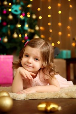 Genç kız bir Noel ağacının yanında yatıyor