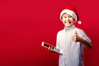 santa delikanlı bir tablet tutarken ok başparmak yukarıya jest yapma
