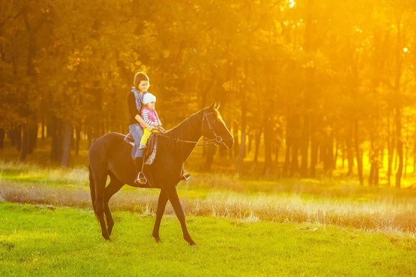 Madre e hija montando un caballo — Foto de Stock