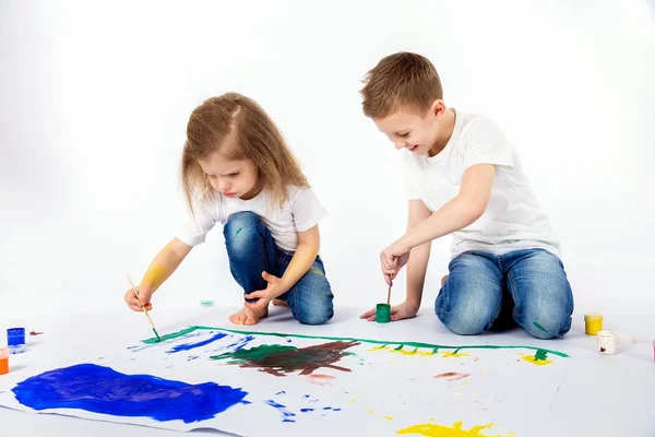 Duas crianças bonitas amigos menino e menina estão desenhando imagens por tintas — Fotografia de Stock