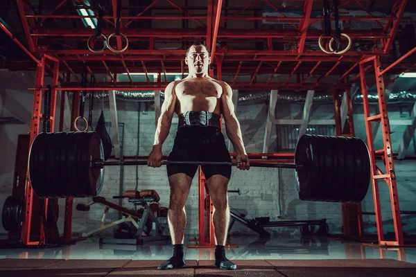 Muskulöser Fitness-Mann beim Kreuzheben einer Langhantel in einem modernen Fitnesscenter. Funktionales Training. — Stockfoto
