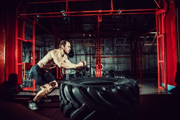 Trainingsmann springt auf Reifen in die Luft — Stockfoto