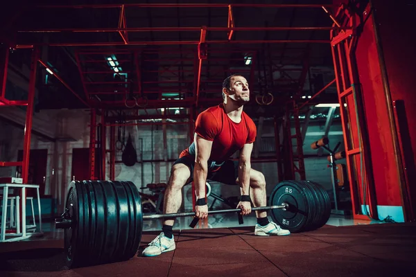 Homem fitness muscular fazendo deadlift um sino no moderno centro de fitness. Treinamento funcional . — Fotografia de Stock