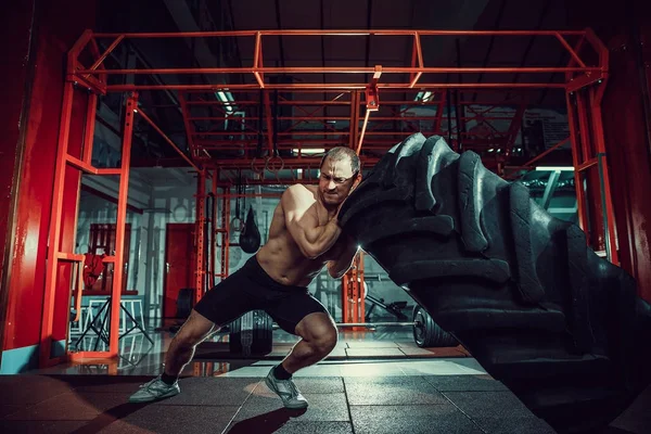 Mann überschlägt sich mit schwerem Reifen — Stockfoto
